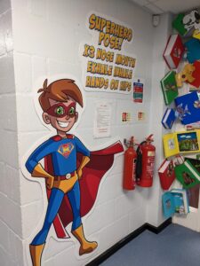 Superhero Sensory Pathway Wall Stickers for Schools Superhero-themed sensory pathway wall sticker in a school hallway, designed to engage and stimulate children's movement and coordination.