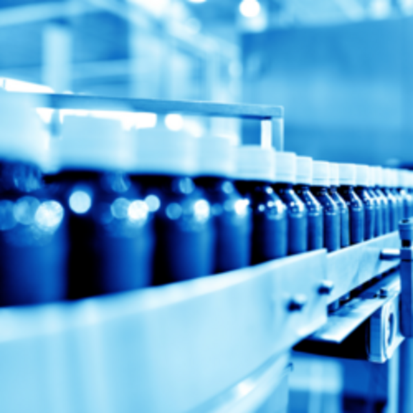 Medicine bottles moving along a production line with precision labelling equipment in a pharmaceutical facility