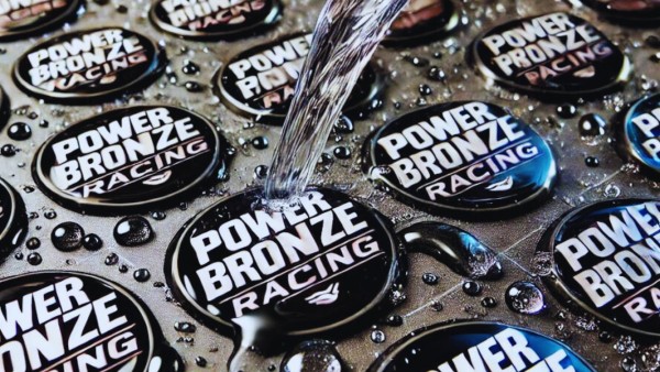 Close up image of domed shape labels made from resin. Black background with white text.